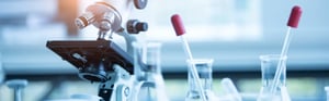 Mikroskop und Laborausrüstung mit Erlenmeyerkolben sowie Pipetten in einem modernen Forschungslabor
