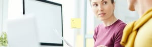 Zwei Kollegen prüfen gemeinsam Dokumente am Computer als Entscheidungshilfe für klinische Leistungsstudien unter der IVDR.