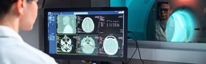 Ärztin analysiert Gehirn-MRT-Scans an einer Medizintechnik-Software am Computerbildschirm