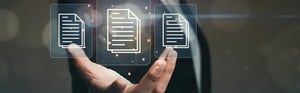 Eine Hand in einem Anzug hält schwebende, leuchtende Symbole für digitale Dokumente und Akten