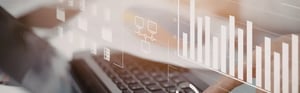 Hände bedienen eine Laptop-Tastatur mit eingeblendeten digitalen Diagrammen und Grafiken zur Datenanalyse