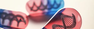 Rote und blaue Kapseln mit DNA-Doppelhelix-Strukturen als Symbol für therapiebegleitende Diagnostika (CDx) und Regulierungen in der personalisierten Medizin.