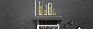 Hände an einer Laptop-Tastatur unter einem abgebildeten Balkendiagramm zur Darstellung von Daten für Klinische Bewertung und PMCF-Updates.