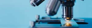 Nahaufnahme eines Labor-Mikroskops zur Analyse von Proben in einem medizinischen Labor gemäß ISO 15189:2022 und den aktuellen Anforderungen an Qualität und Kompetenz.