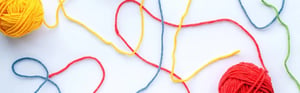 Colorful yarn threads with interconnected patterns symbolizing traceability, verification, validation, and structured processes in medical device development and quality assurance.