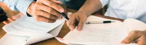 Professionals reviewing technical documents and research papers, representing literature review, clinical evaluation, MDR compliance, and evidence-based documentation for medical devices.