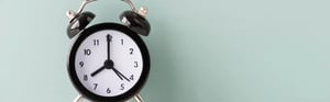 Black analog alarm clock on a clean surface against a light background, symbolizing regulatory deadlines, MDR and IVDR transition periods, compliance timelines, and medical device certification planning.