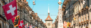 Bern’s historic old town, featuring Swiss flags and the Zytglogge Tower—a symbol of the Swiss medical technology industry and regulatory requirements in the healthcare sector.