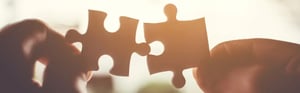 Two puzzle pieces are joined together, symbolizing the connection between risk management and fitness for use in medical devices.