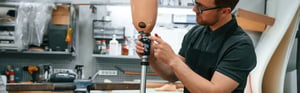 Techniker passt eine patientenspezifische Beinprothese an und fertigt ein maßgeschneidertes Medizinprodukt an