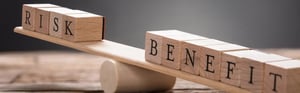 Waage mit den Begriffen „Risk“ und „Benefit“ als Symbol für die Nutzen-Risiko-Bewertung von Medizinprodukten im Rahmen regulatorischer Anforderungen nach MDR und IVDR.